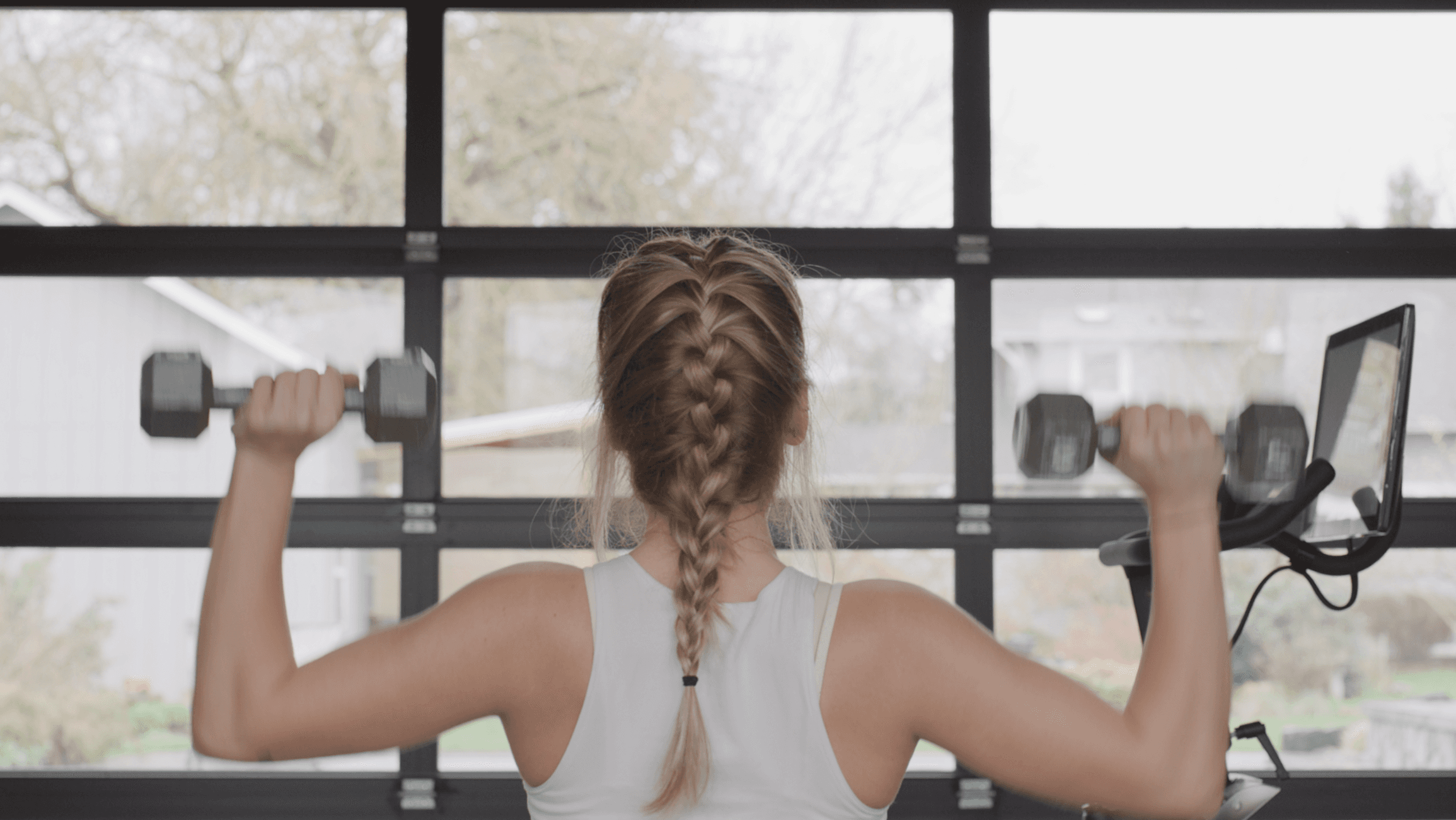 Woman performing dumbbell shoulder presses during a strength workout