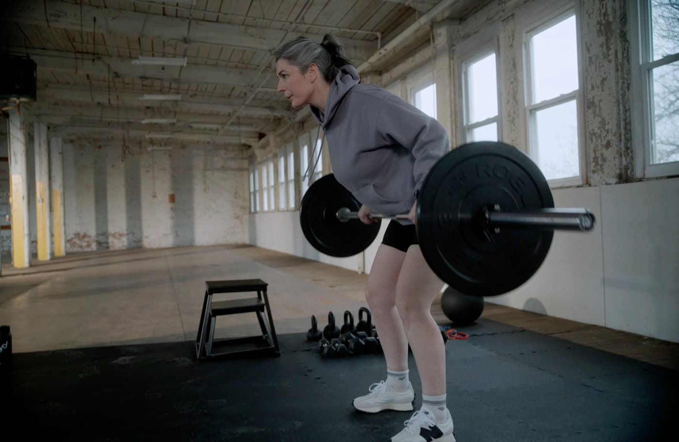 Person strength training with a barbell row in a gym