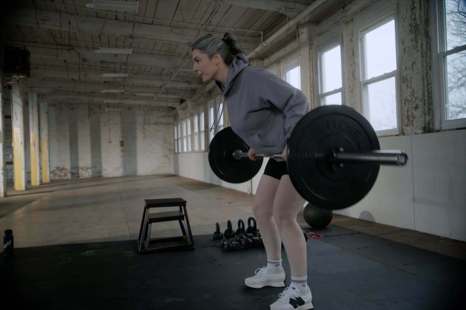 Woman over 40 performing a barbell row during a strength training workout in the gym
