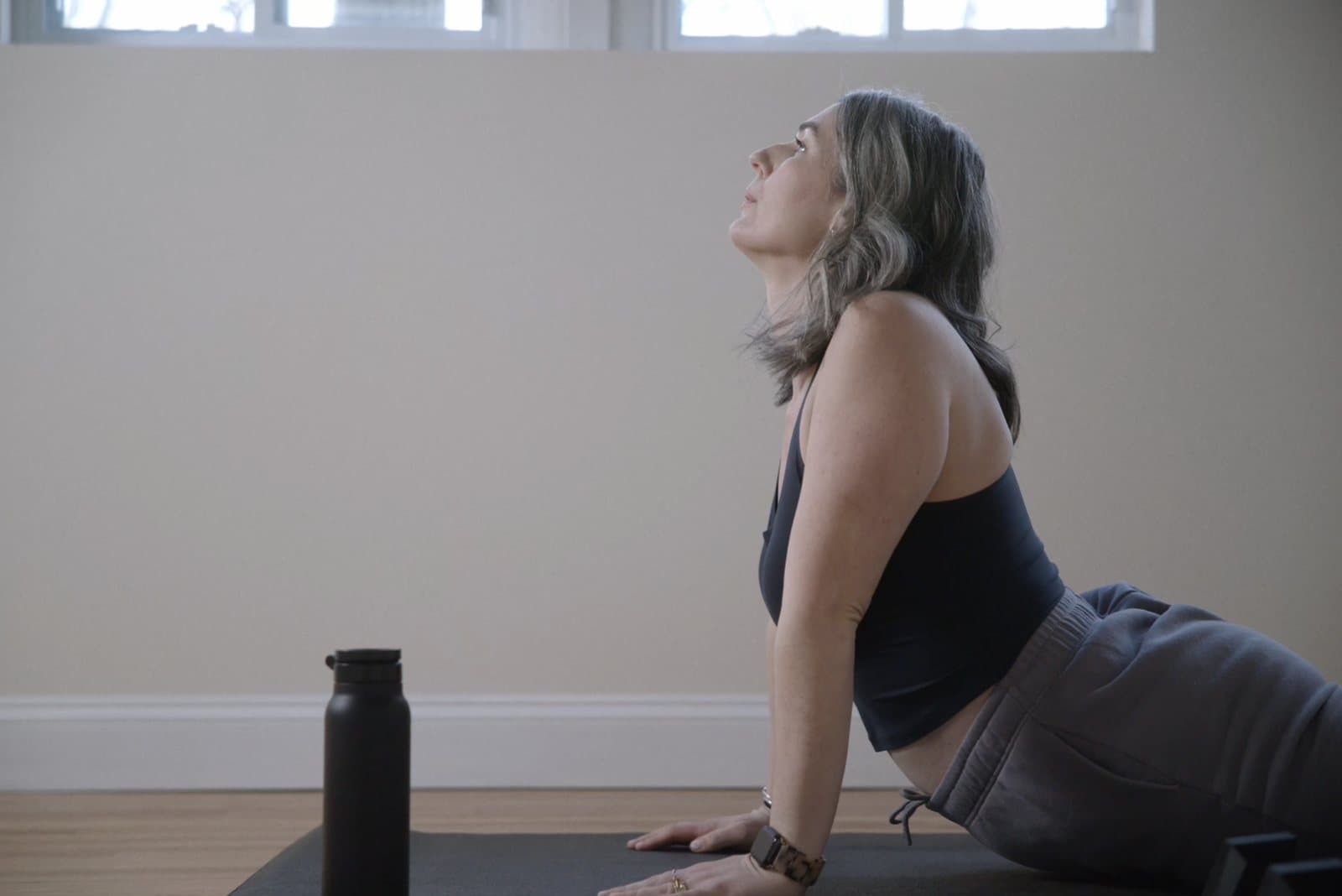 Woman over 40 doing a mobility and recovery movement on a workout mat