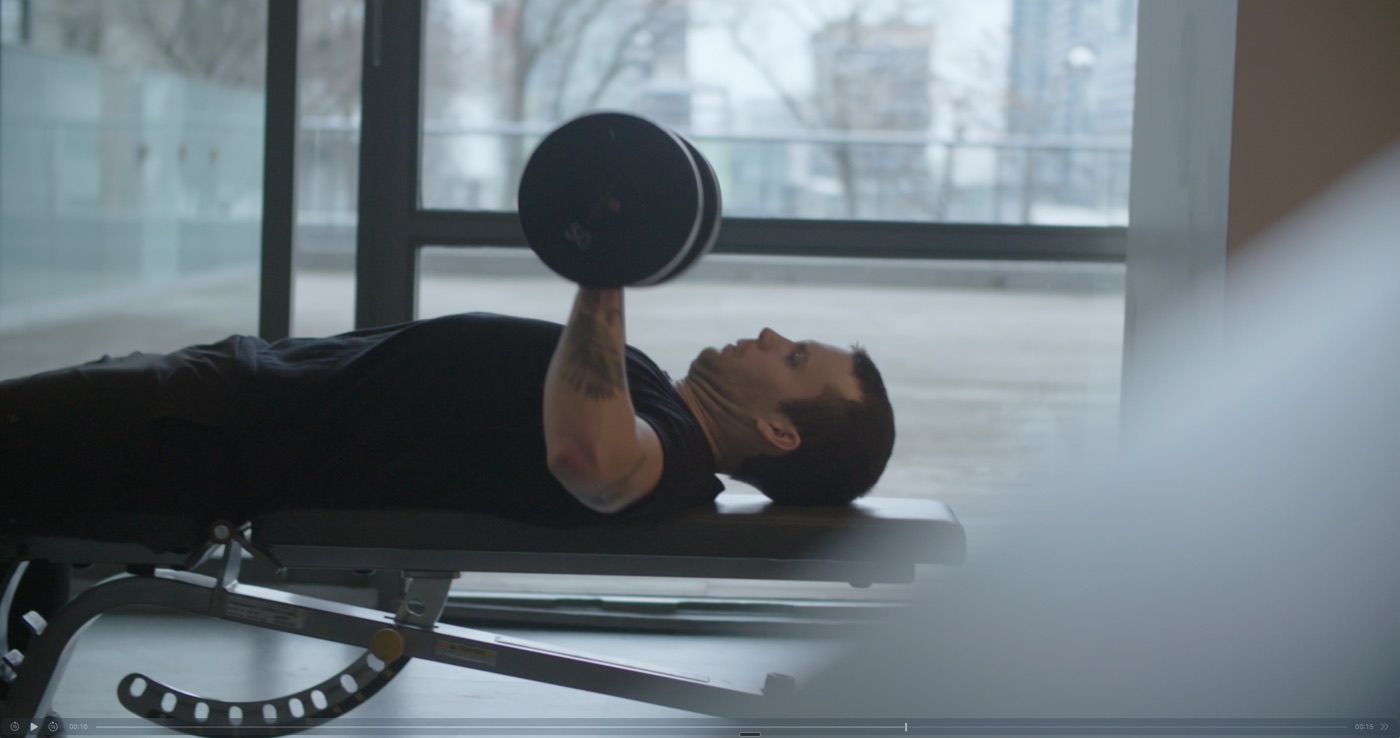 Person doing a dumbbell bench press during a strength workout
