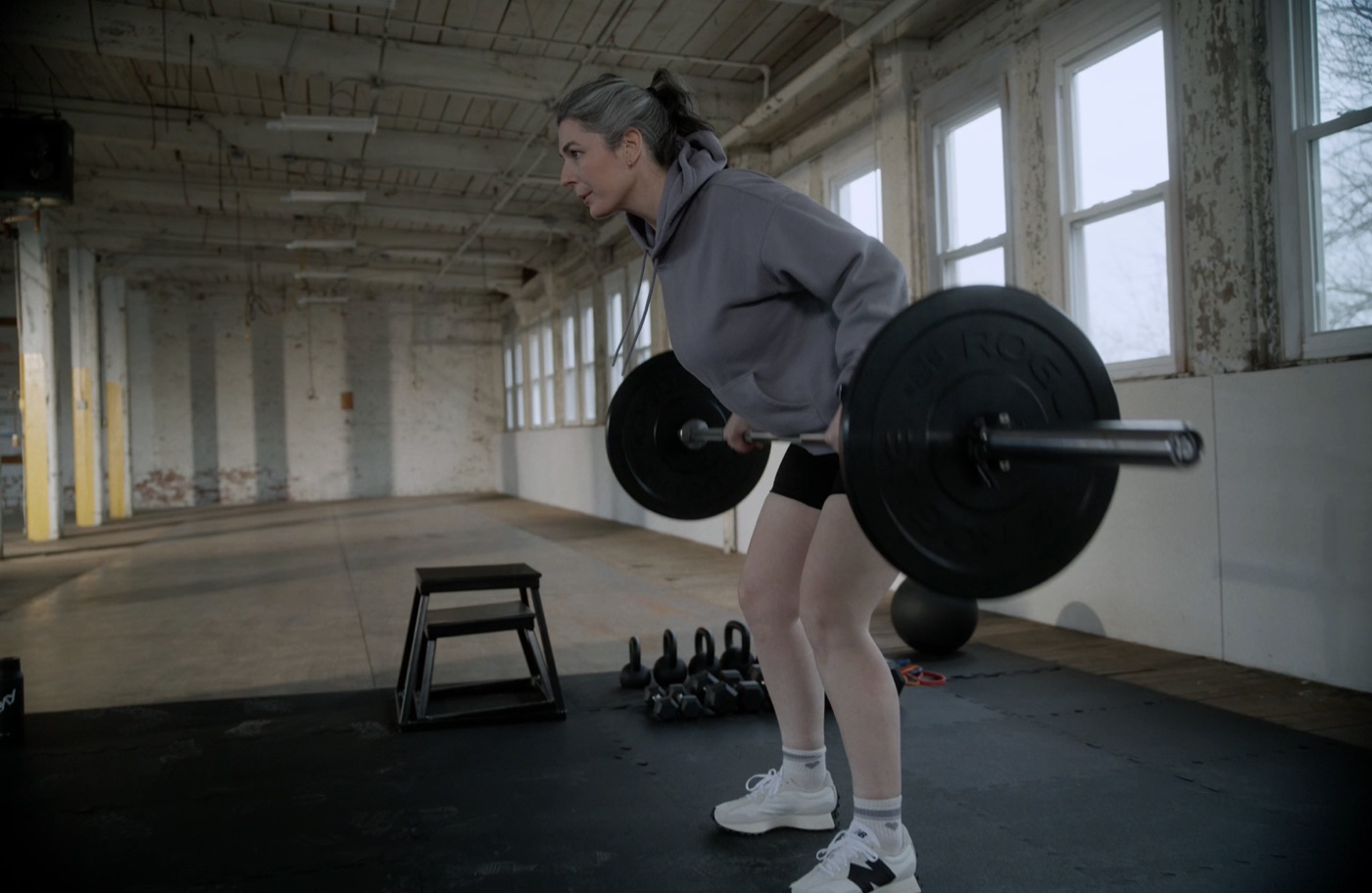 Person strength training with a barbell row in a gym